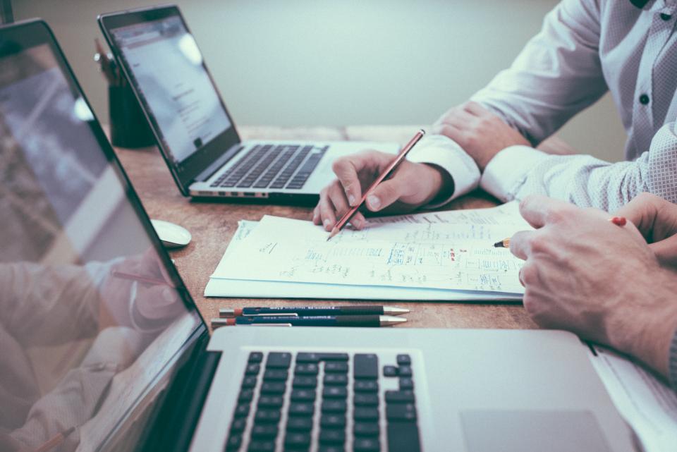 Mesa de trabalho com notebooks e planejamento de SEO técnico